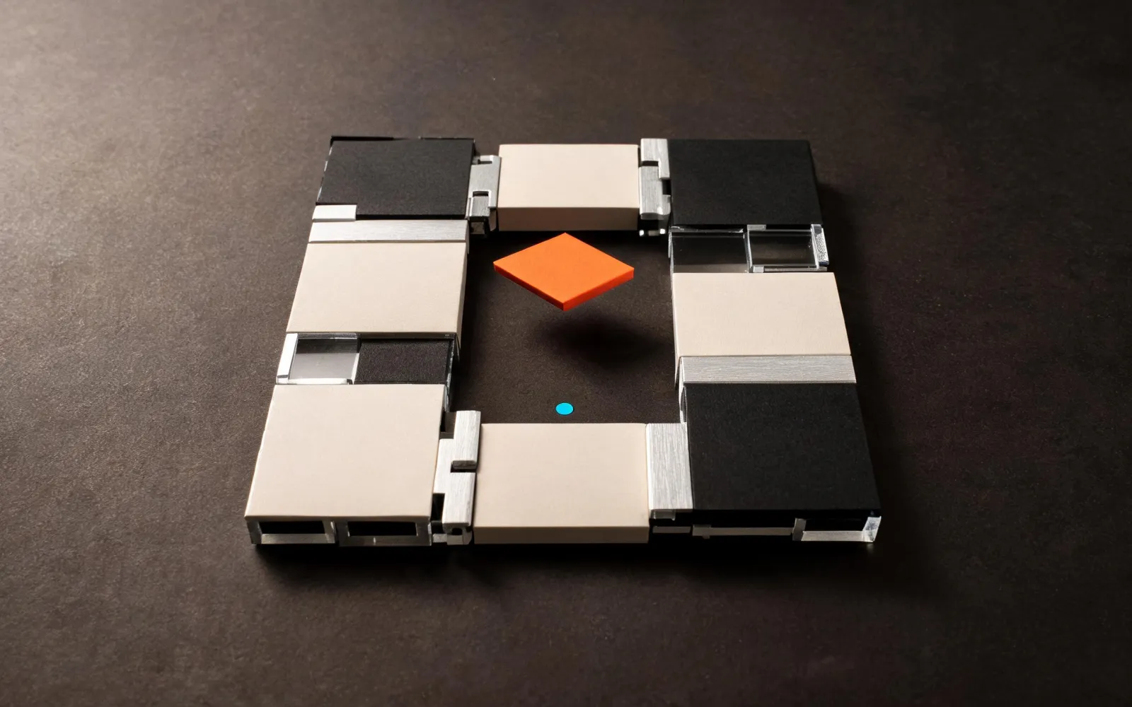 A modular assembly with one orange keystone ready to complete the system