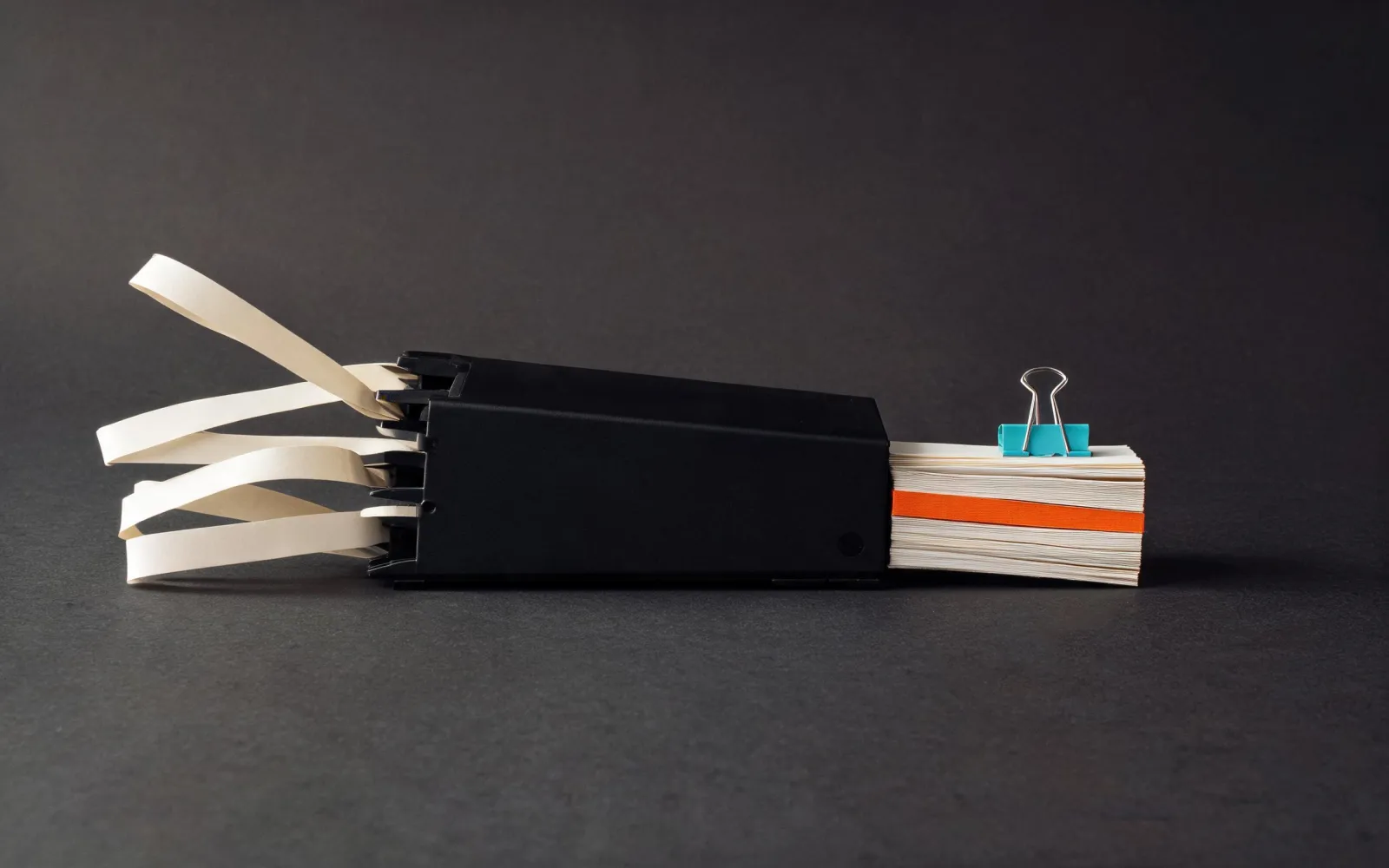 Loose paper streams entering a black archive and leaving as an ordered stack