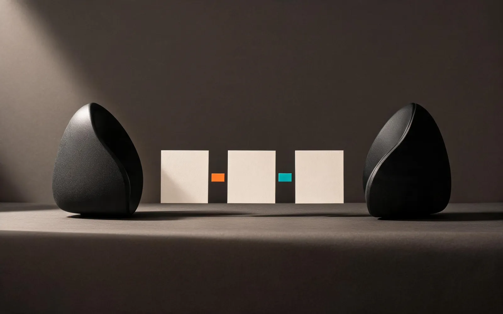 Two black acoustic forms facing a sequence of rehearsal cards